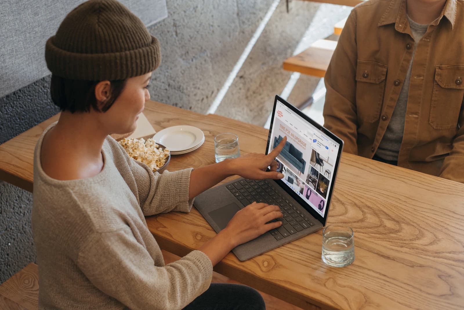 Two people reviewing information on a laptop across a shared office table